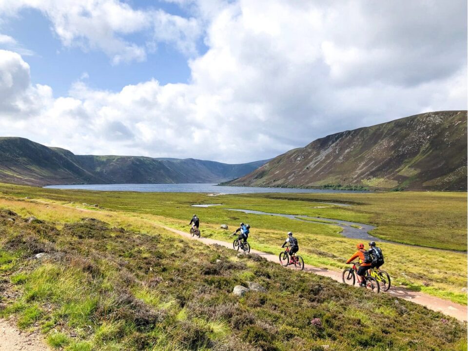 Group of People Riding Bicycles Near a Lake in Scotland