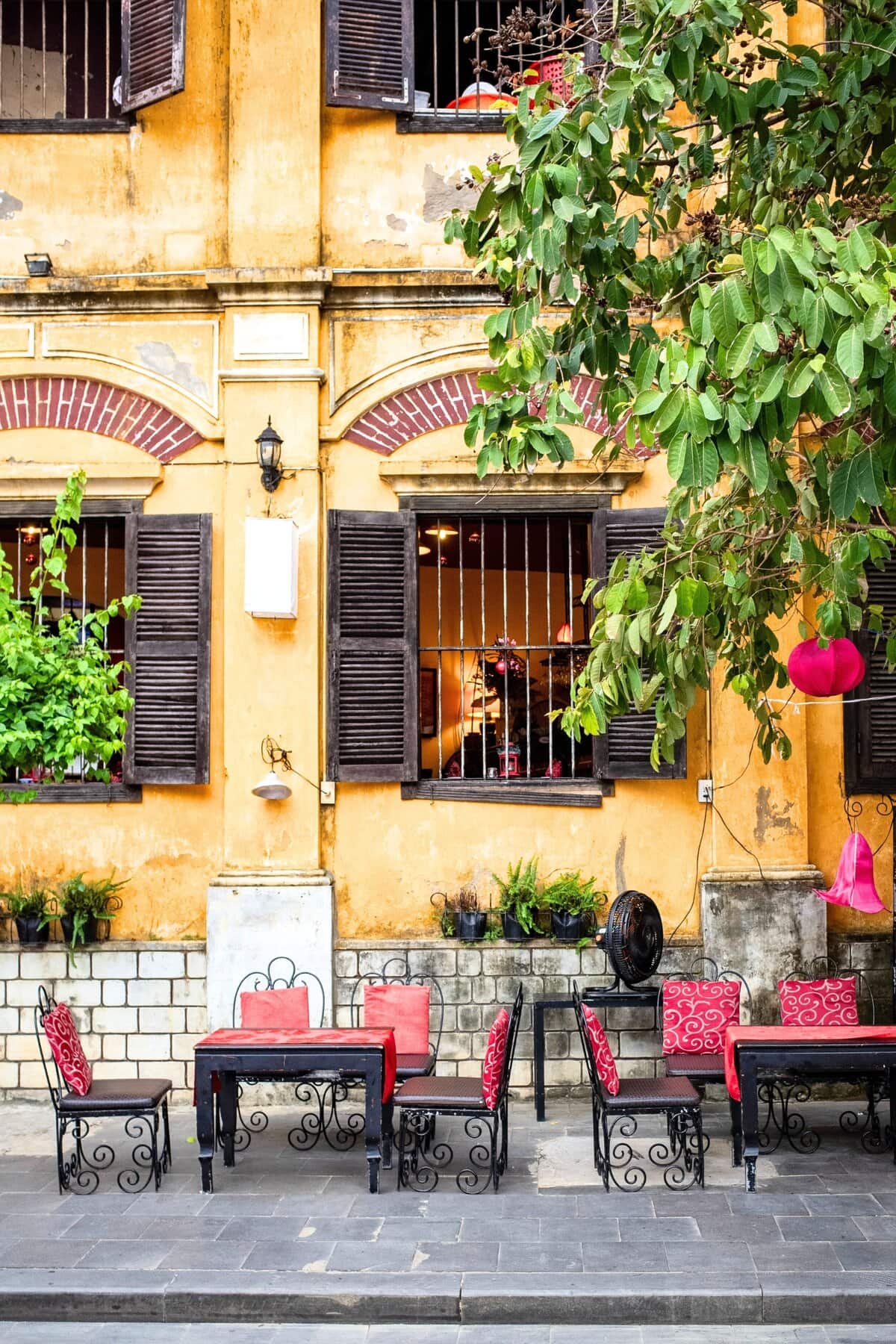 Cafe Setting Against Hoi an S Signature Yellow Walls