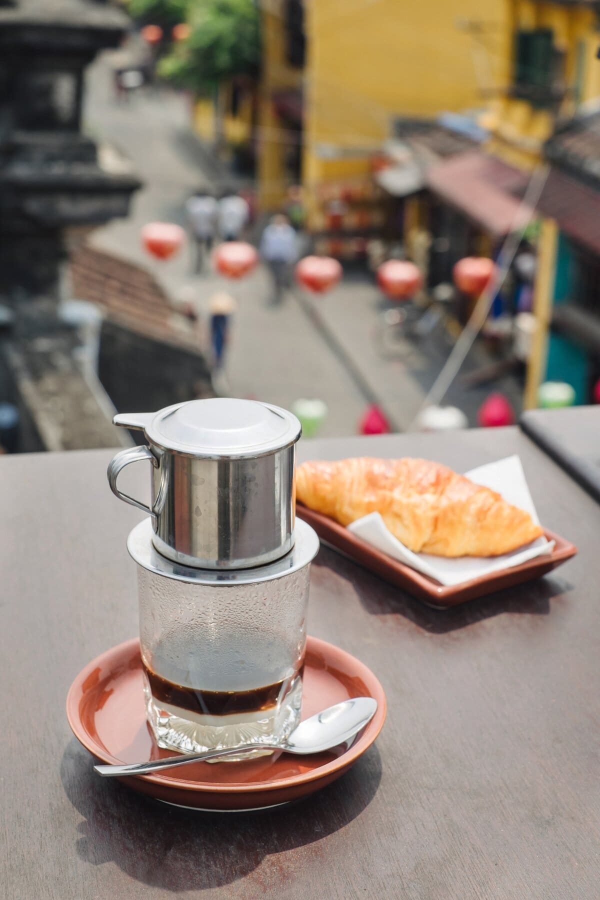 Vietnamese Coffee and Croissant on the Table with View on Hoi an City