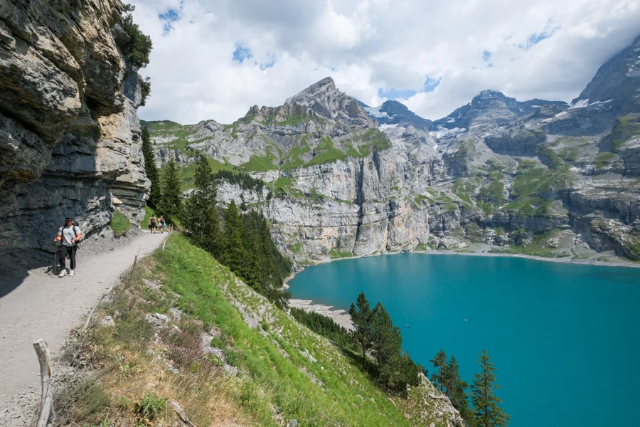 Hiking along the edge of the Oeschinensee lake trail