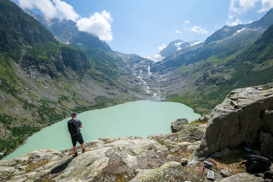Hiker looking at Triftsee glacial lake